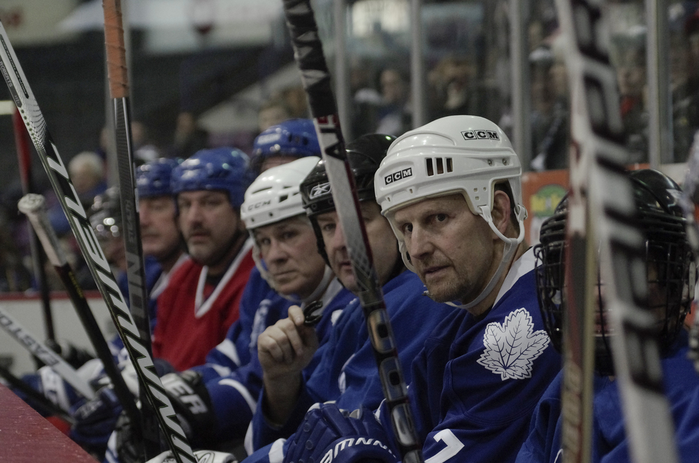  Gary Roberts (far right) rests on the bench during a charity match in Brampton at the Powerade Centre on February 9, 2015. &nbsp;Other NHL Alumni present included Gilbert Dionne (in red) and Rick Vaive (centre, white helmet). &nbsp;As published in S