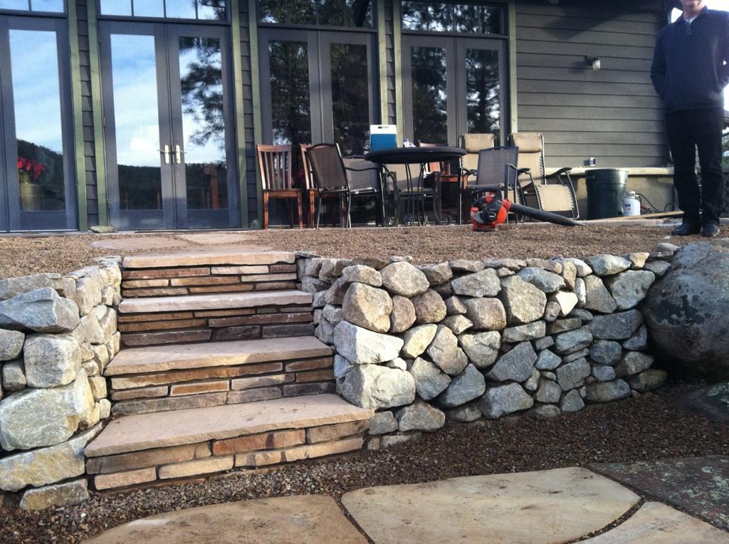 Dry stacked granite retaining wall with flagstone steps.
