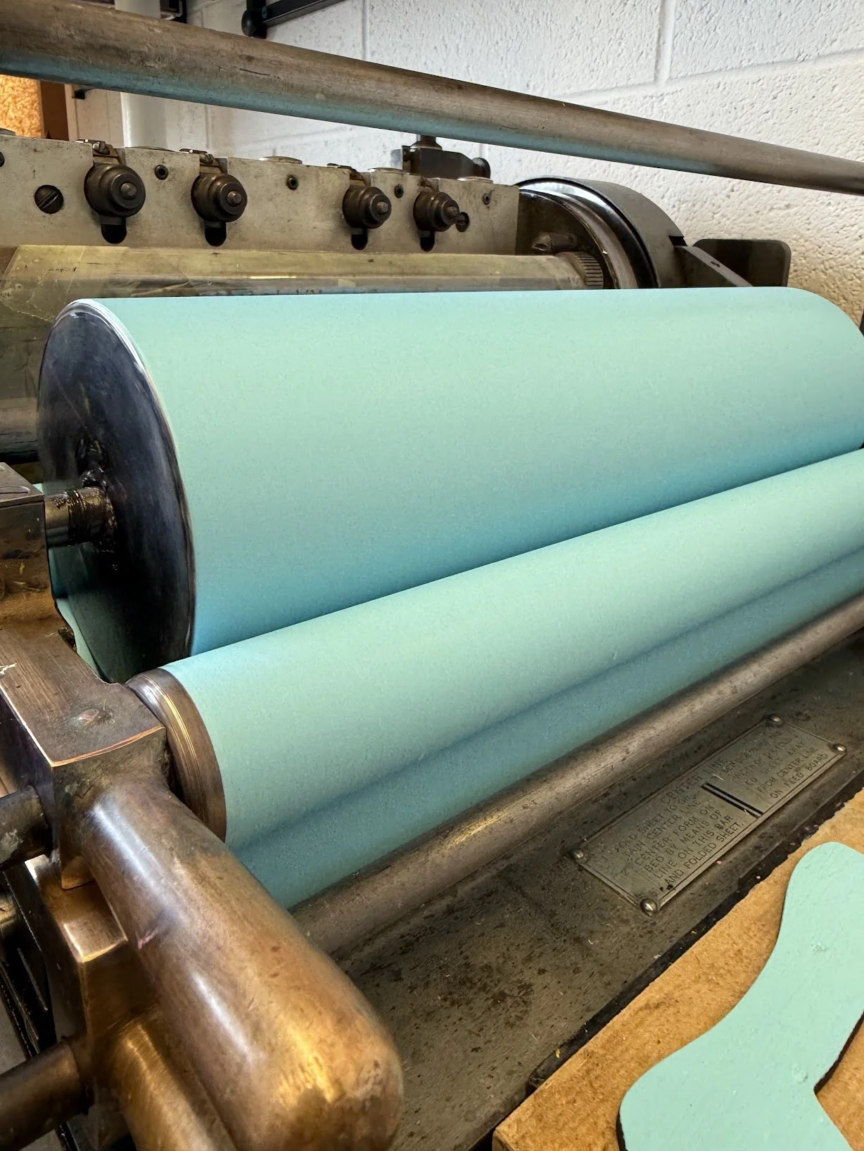 Vandercook proof press with inked rollers in a letterpress printing studio.