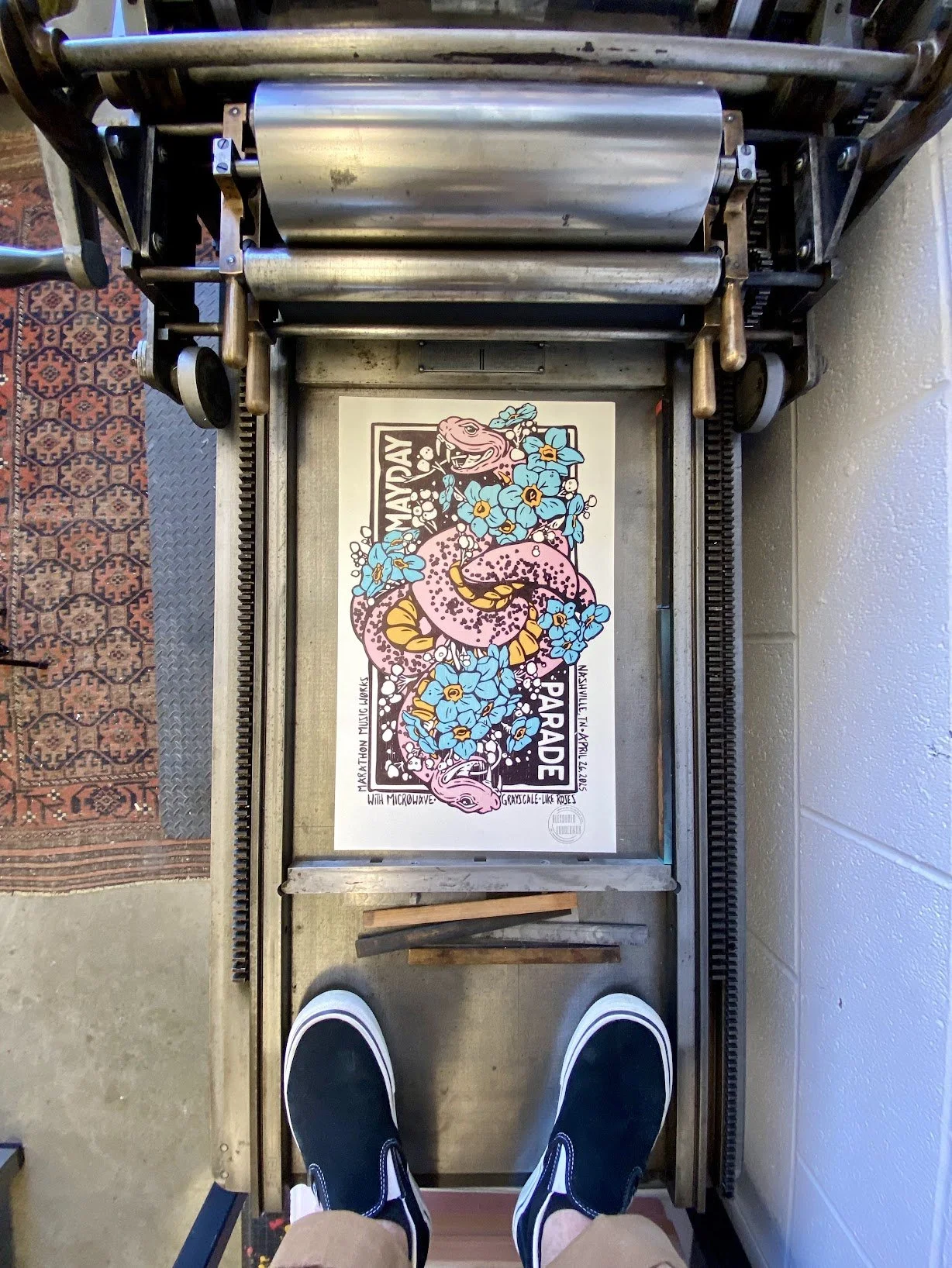 Alexander Landerman standing at a Vandercook letterpress proofing press in his studio