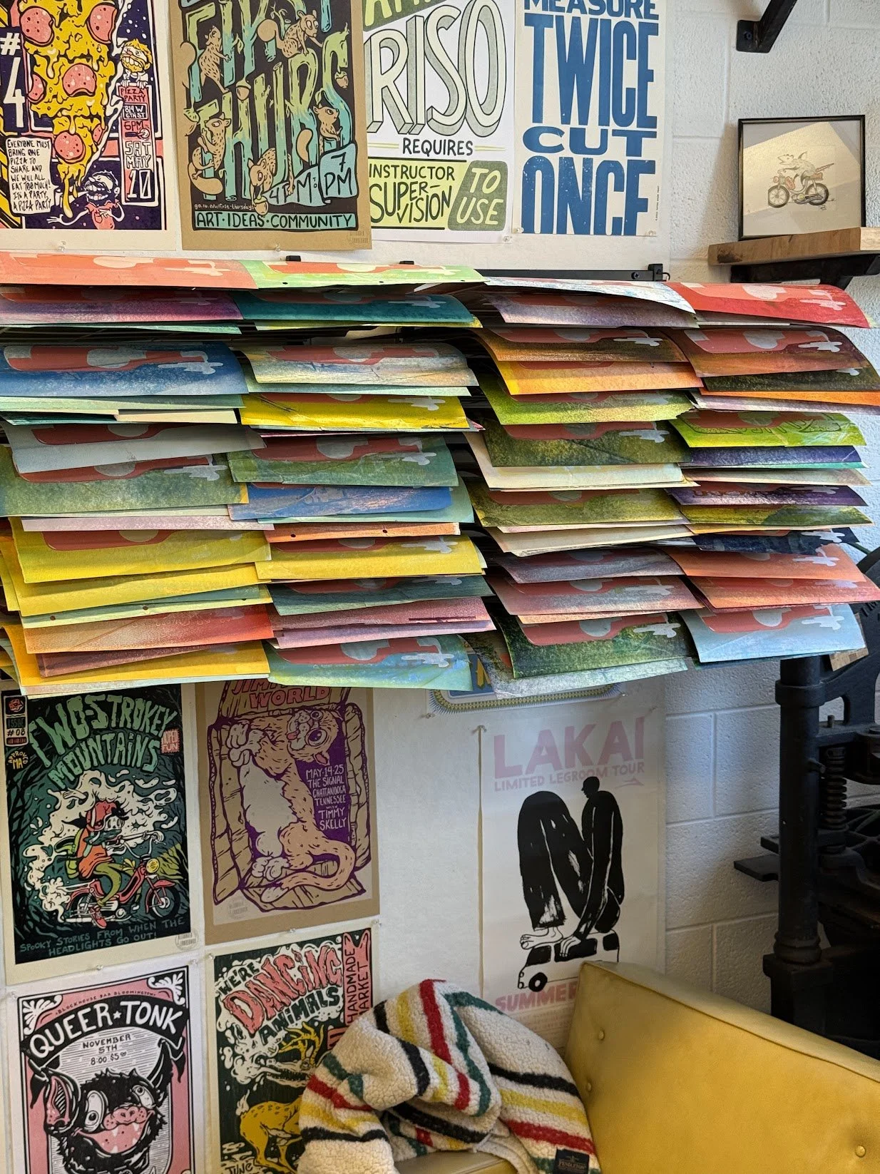Hand-printed concert posters drying in racks inside the relief printing studio in Bloomington, Indiana.