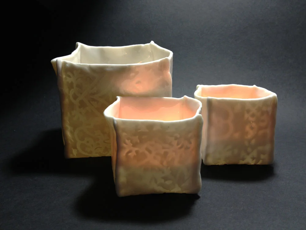 Porcelain lanterns emit a warm candlelight glow. Unglazed on the outside with a clear glaze inside. These are 3" X 3" and 2" X 2". Other sizes and colors available. Can also be made as light pendants.