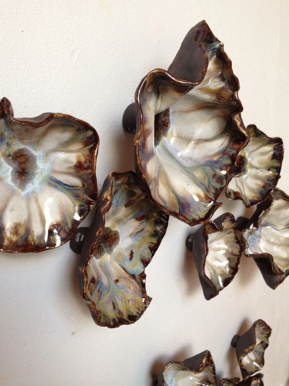 From 2" to 8", glazed stoneware. This is part of a 8ft x 3ft wall installation