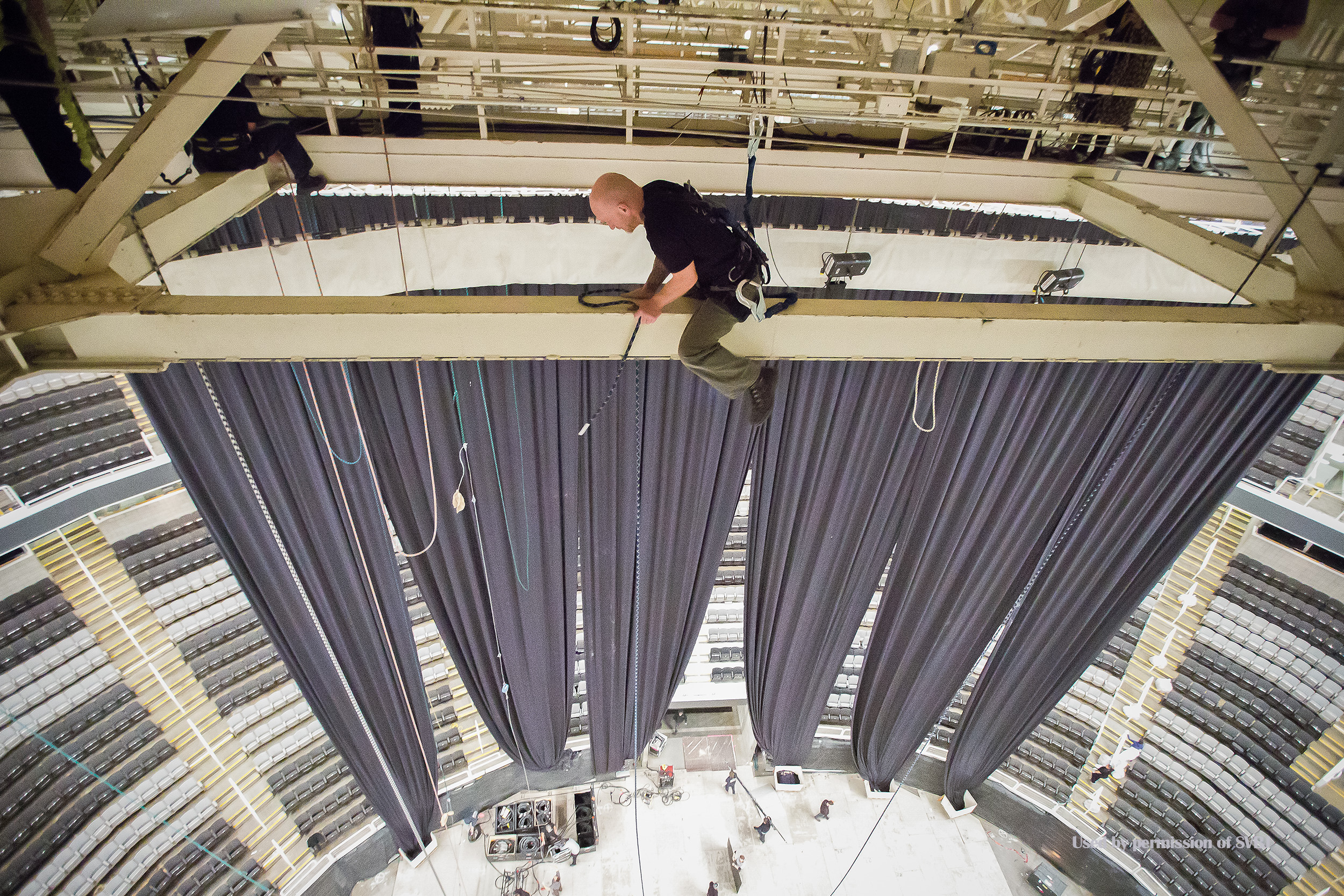 While on an assignment covering what happens between a concert and a Sharks game, I caught this rigger in a precarious position while lowering the lights. 