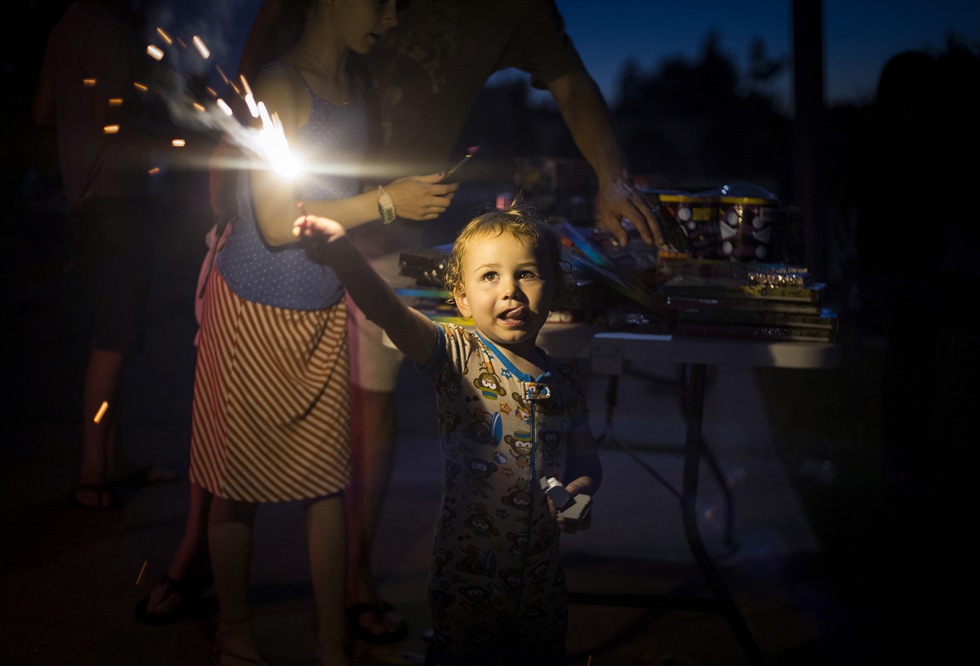  A boy experiences his first sparkler on the 4th of July.  