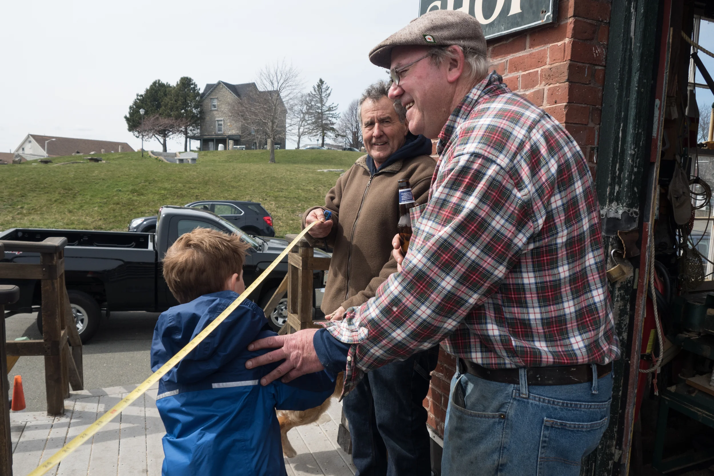   Geno’s friend jokes with him by explaining to the child the difference in the their age by using a measuring stick from 7 to 68.  