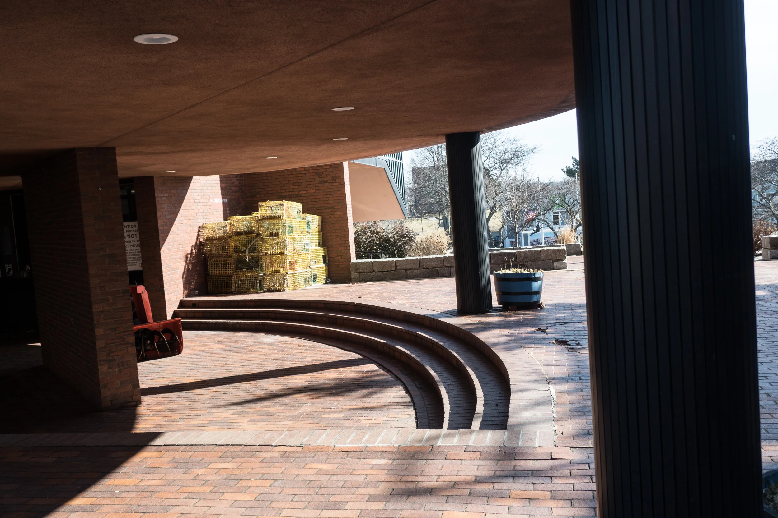  Lobster pots resting outside of the courthouse in Gloucester. During the off season months, lobster pots, equipment and memorabilia can be found on the docks, harbor walk or outside homes, for both aesthetic and storage purposes.  