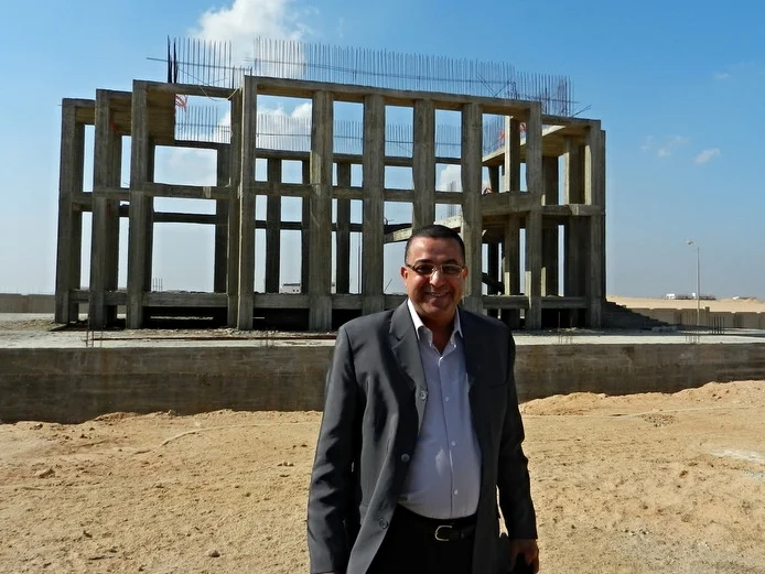 Rev. Awni Salib with construction skeleton behind him