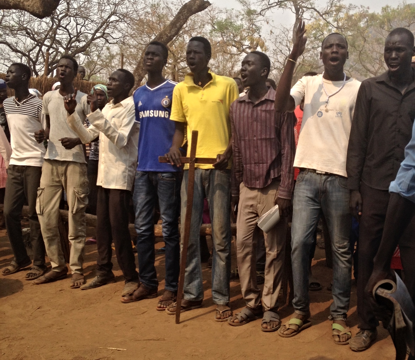 Older youth in refugee camp praising God in loud, fervent song.