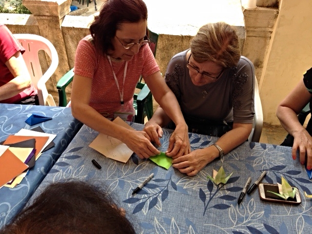 Maahsen, on the left, helps another woman learn the art of origami cranes. Maahsen is from Hasakeh, and she is a good teacher!