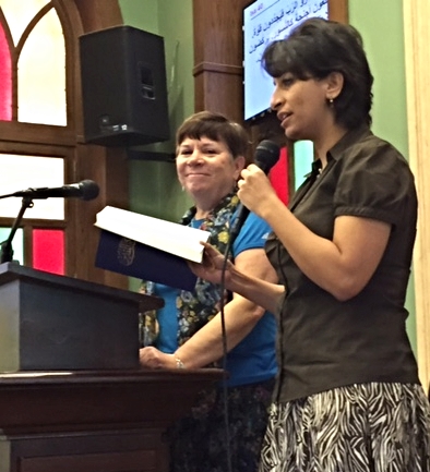 Rev. Deena Candler preaching with Professor Anne Zaki translating
