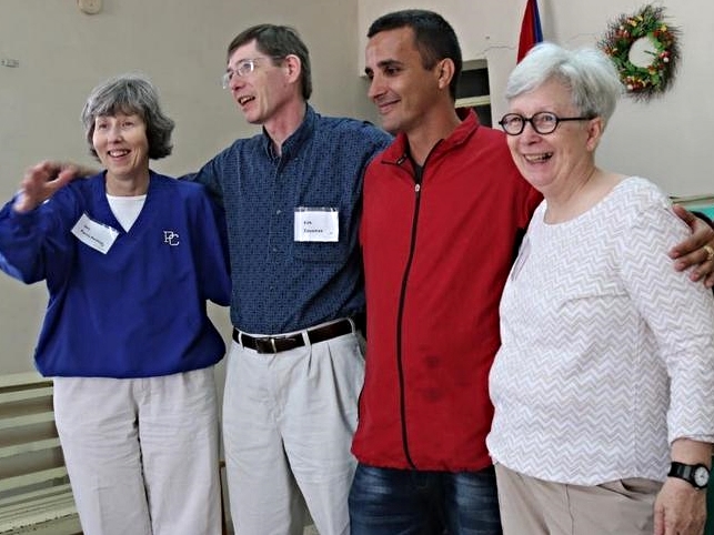 Lester (in red) receives a prayer and an embrace from three pastors who were part of a recent Outreach Foundation trip: Jeri Parris Perkins, Kirk Dausman and Camille Josey.