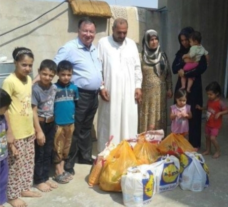 Rev. Haitham of the Presbyterian Church in Kirkuk, Iraq shown delivering food and water to neighbors not from his congregation