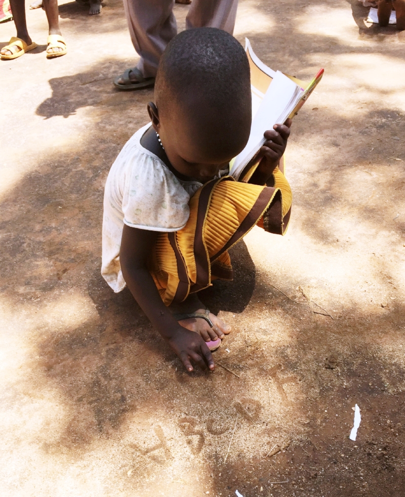 Refugee Nyadoang proudly writes her ABCs in the dirt of the Gambella refugee camp.