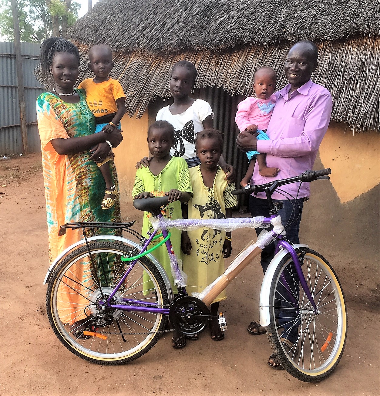  John Jock Gatwech family at their home and new Outreach-purchased Bike for his coordination work in the camps 