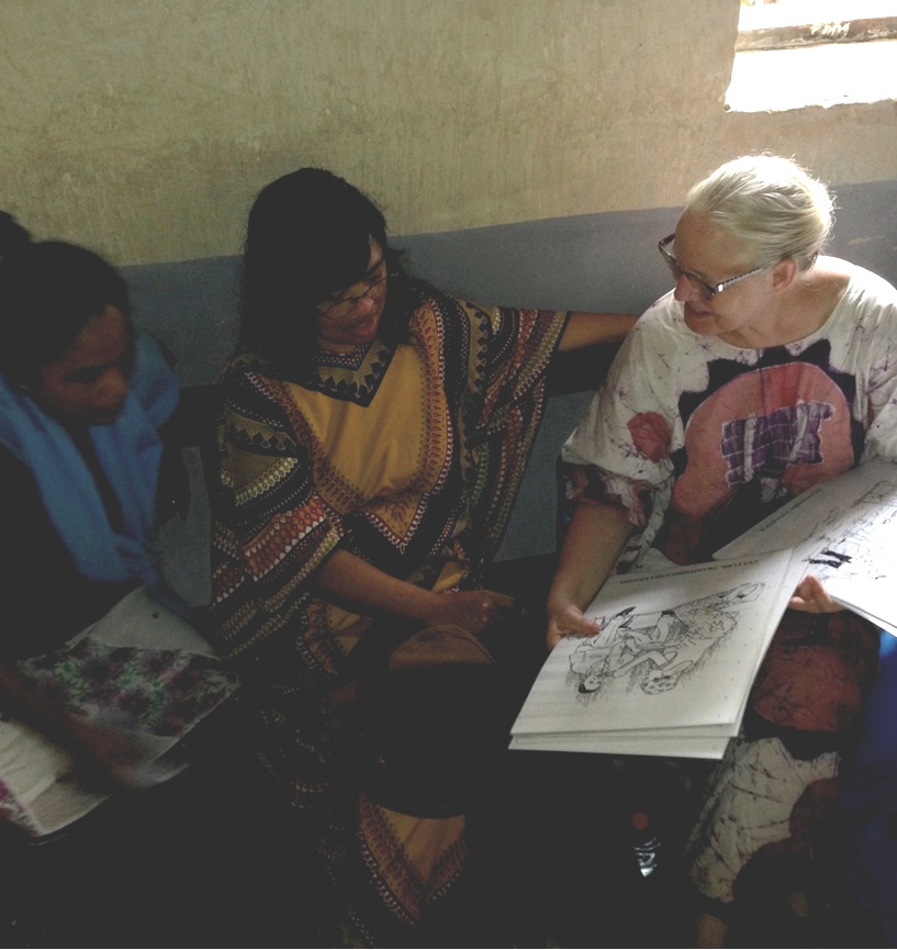 Christi Boyd showing Pastors Helivao and Noro some of the domestic violence awareness materials that the churches in the DRC are using.