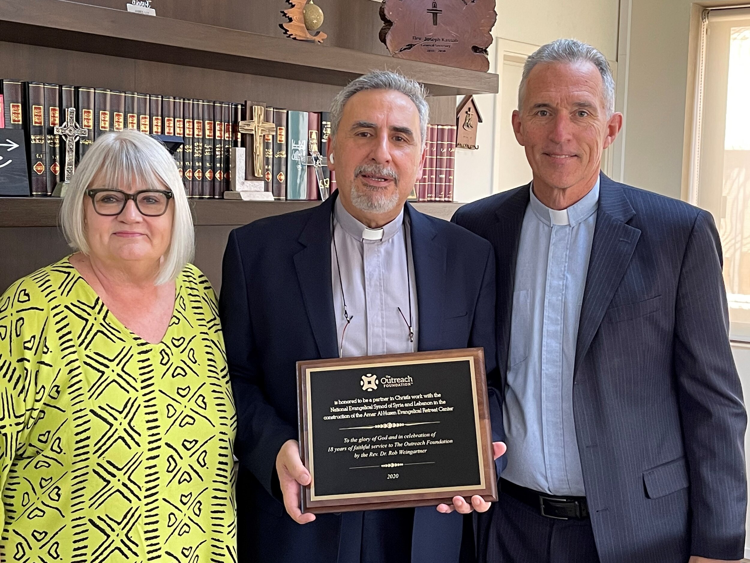  Marilyn and Mark (Outreach’s new Executive Director) present Rev. Kassab with a dedication plaque for the Retreat Center in Syria which honors Rob Weingartner, Outreach’s former Executive Director&nbsp; 
