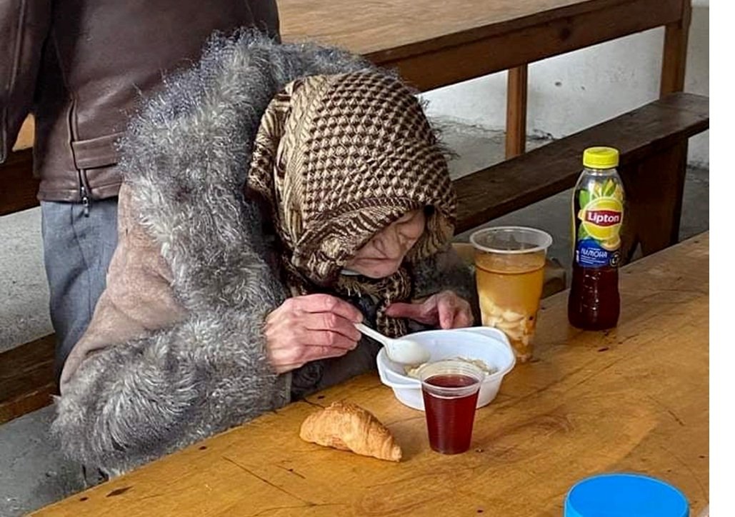 Woman eating a bowl of hot soup at the church