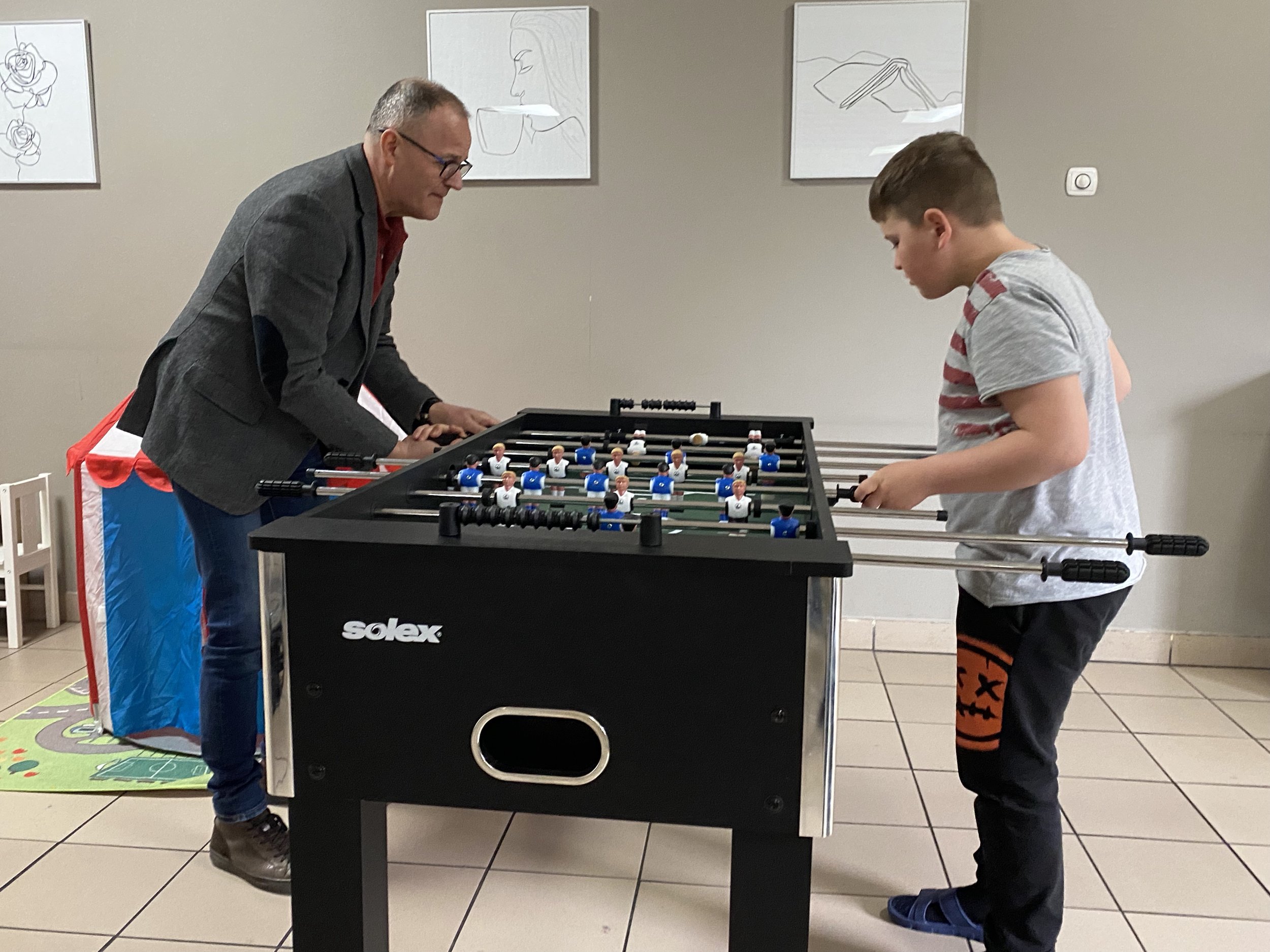 Piotr Nowak playing table soccer with one of the Ukrainian children