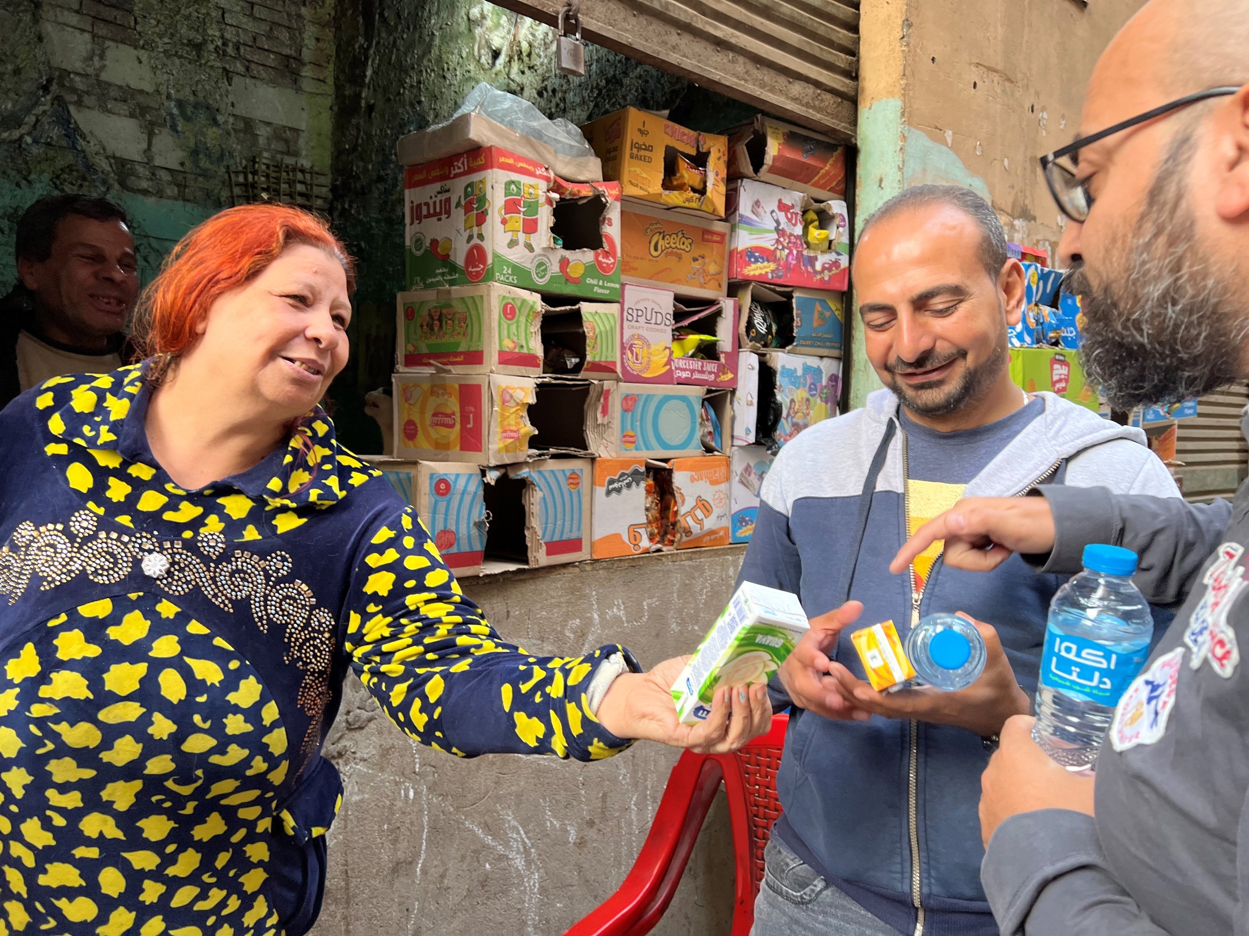 TOLI Staff Saed and Maged with shopkeeper Mona at her street side snack-shop (husband in background)