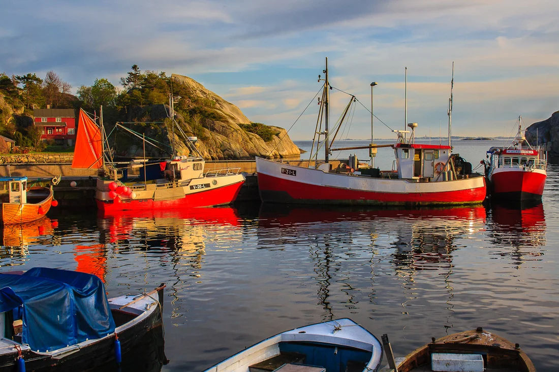 Rolig vårkveld i Ula. Det er en av de første kveldene i mai og fortsatt lenge til sommergjestene skal myldre i Ulas havneområde. Fiskebåtene vugger hvilende før de ved neste dags gry skal bli med sin skipper ut i Skagerrak.