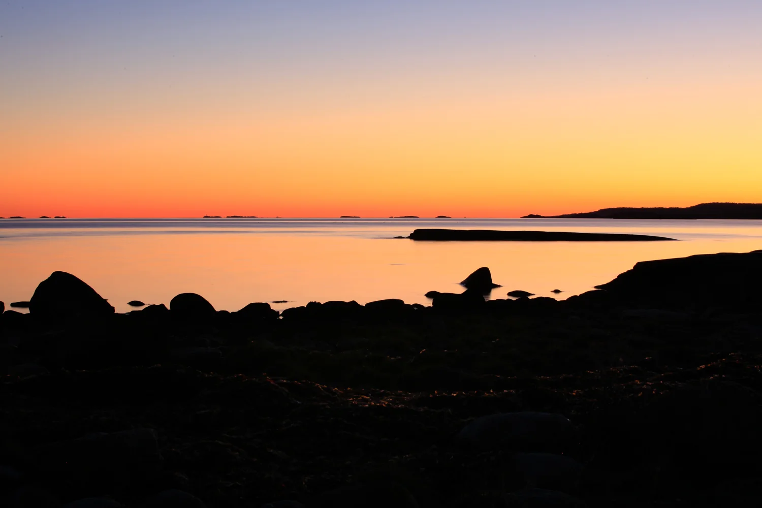 Horisont over skjæringspunktet Oslofjorden - Skagerrak. Ytterste del av Østerøya i Sandefjord bakerst til høyre i bildet. Bildet fotografert fra fjæresteinene i Moutmarka, Tjøme.