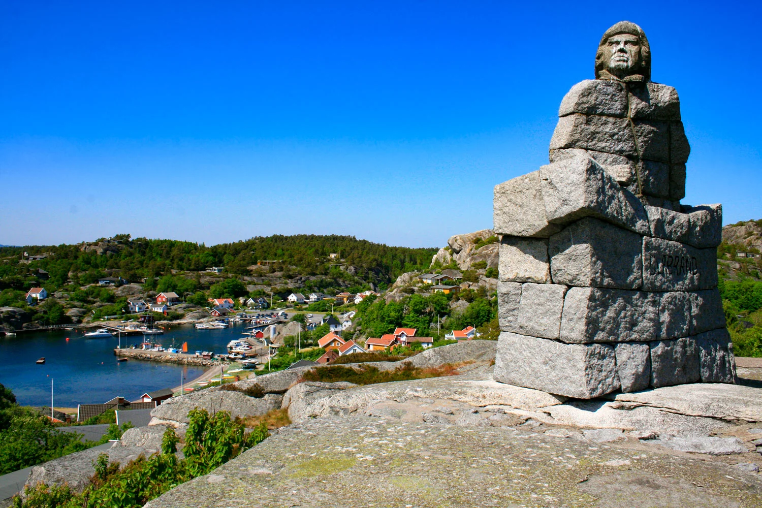 Ulabrand med fantastisk beliggenhet. På en høyde over Ula troner monumentet av Ulabrand. Fra havnen i Ula går det en godt merket sti opp til monumentet. Monumentet er hogd i stein av billedhugger Hans Holmen, og satt opp av Tjølling Sangforening i 1932. Klikk på bildet for å forstørre.