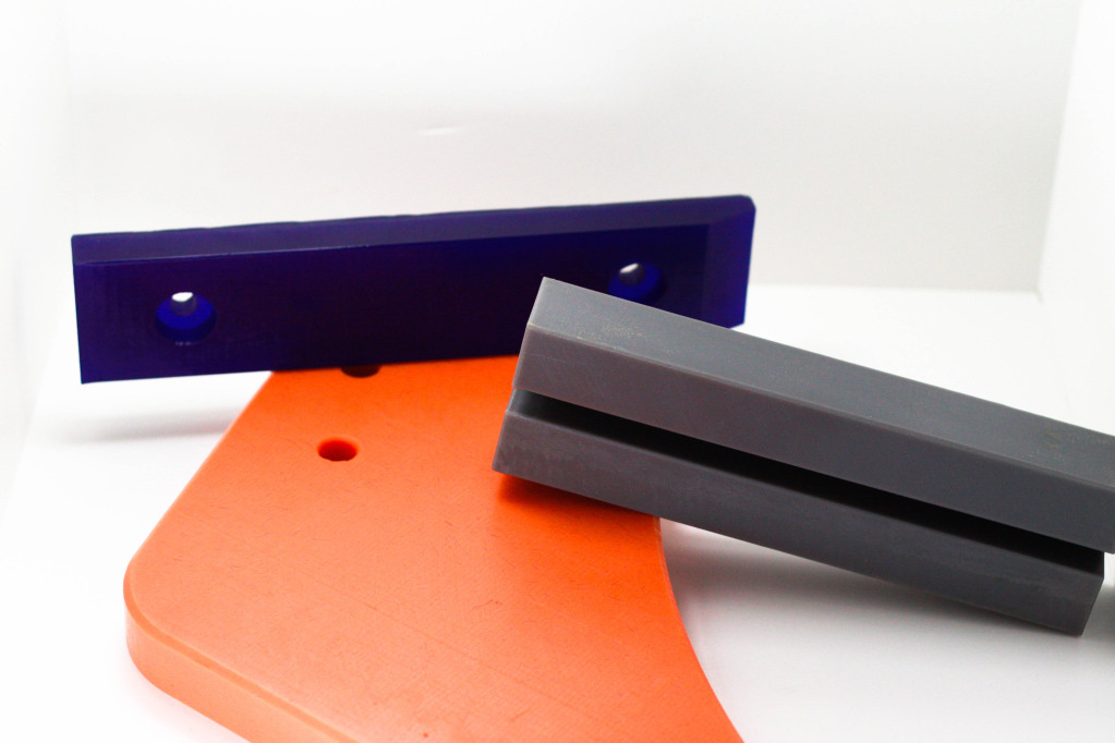 Blue Urethane Skid Bars; Orange Reprocessed UHMW-PE Diverter Arm; Oil filled UHMW-PE Chain Guide