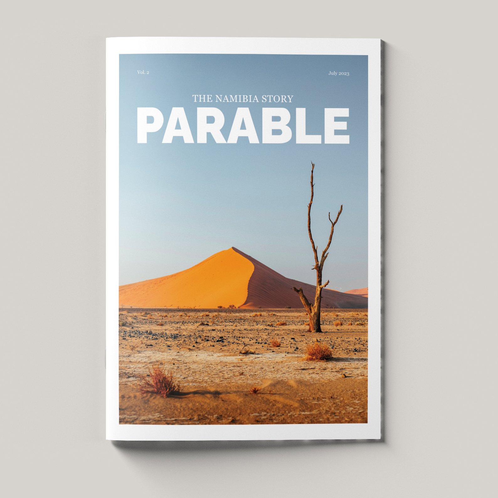 Magazine cover titled 'The Namibia Story Parable' featuring a desert landscape with a sand dune, a leafless tree, and sparse vegetation.