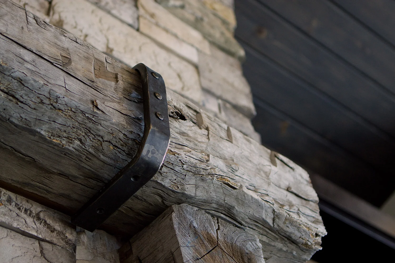 hand hewn fireplace mantle adorned with custom iron brackets