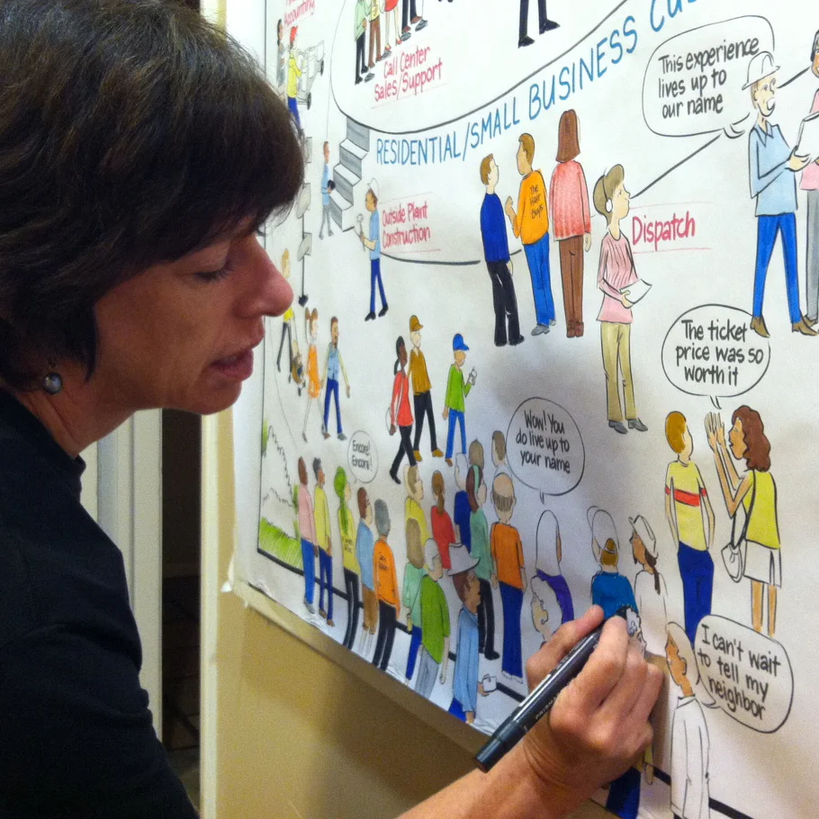 Sue Fody hand-coloring a large studio map at Wittmann Studios.