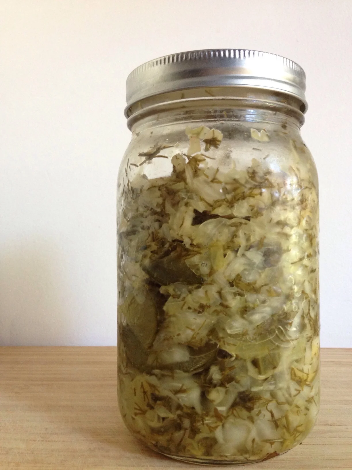 After fermentation the dill and cucumber skins have discoloured and the brine has become cloudy