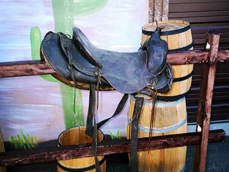 Assorted Western Props: Wooden Barrels, Hitching Posts, Saddle Blankets and Horse Saddle