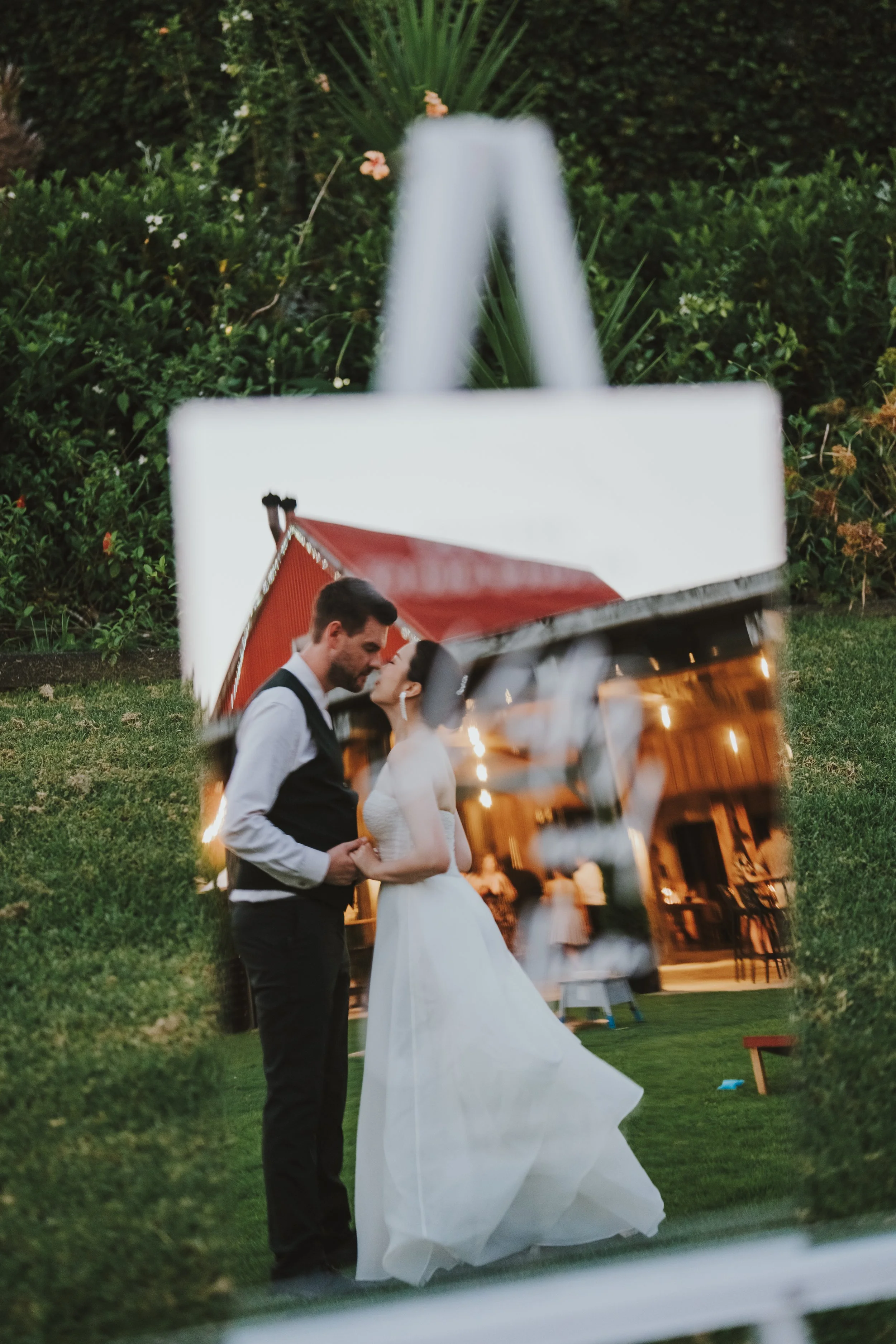 Couple kissing in a mirror with the stables reflection inside