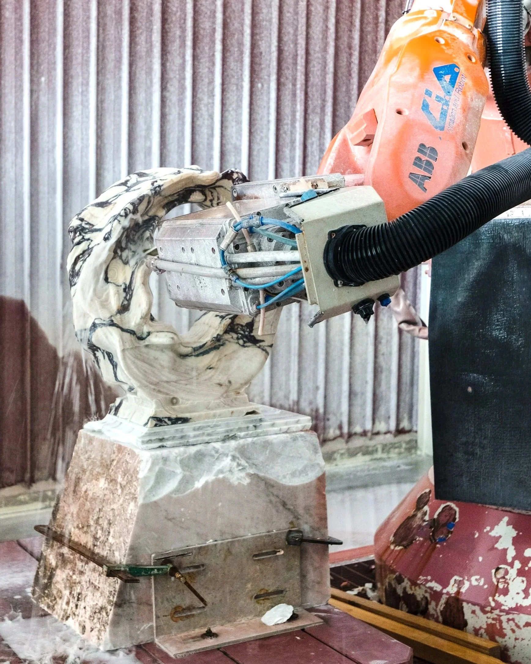 Industrial robot arm sculpting marble with a mechanical tool