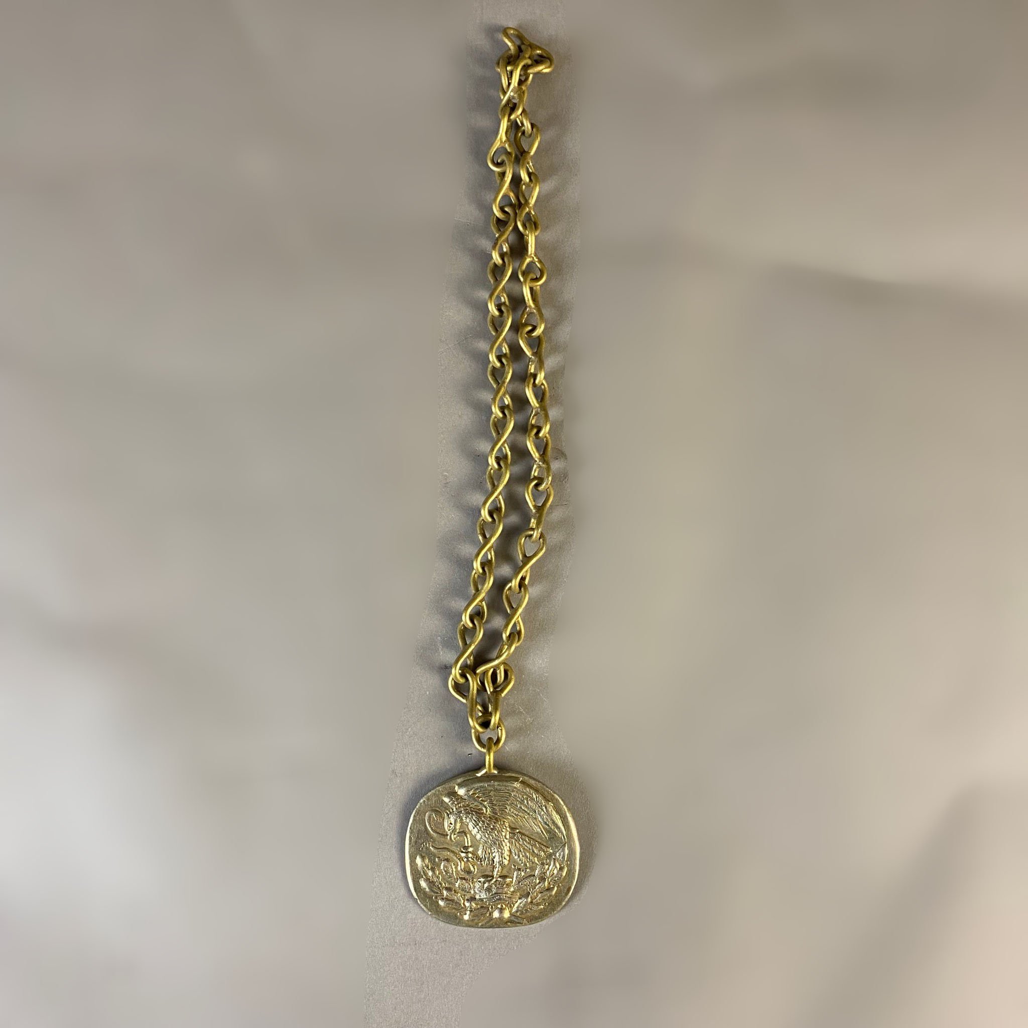  Collar estilo Brutalista. México, años 70. Bronce. Diseño con pendiente de águila mexicana y eslabones en forma de 8.  Peso: 113 g. 