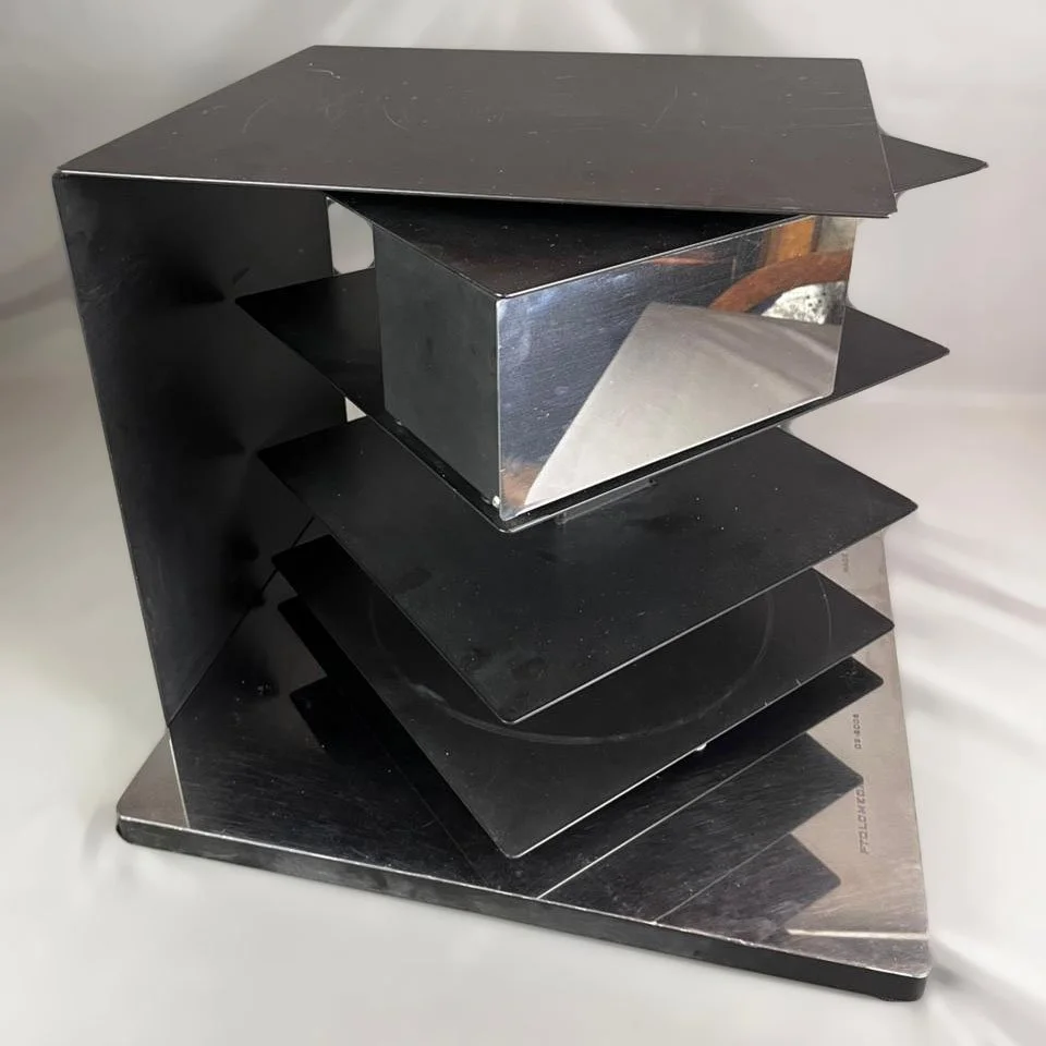   Bruno Rainaldi para Opinion Ciatti. Mesa lateral / de centro / librero PtolomeoX4 Short en acero laqueado negro y cromado.   47 x 53 x 53 cm. 