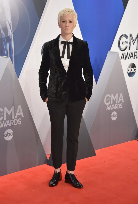 Megan Rapinoe in a black velvet blazer, bowtie, and slacks. This professional soccer player knows how to rock a suit. Rapinoe looked extra sharp in a velvet blazer (VERY fall 2015!) with a white shirt underneath and a cute bowtie tied at the collar. It was a playful addition to an outfit that could have otherwise been to an outfit that could have otherwise been a bit dull.