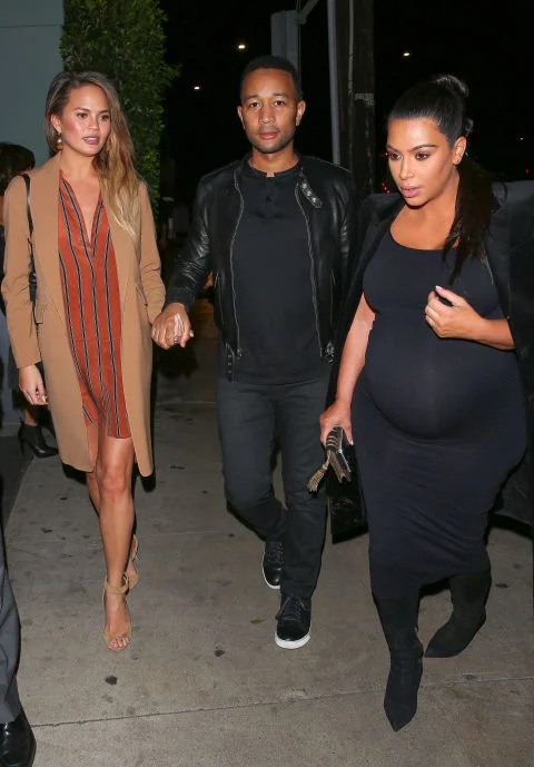 Keeping her baby bump hidden in a striped orange shirt-dress and camel coat paired with nude heels during a double date with her husband, John Legend, and Kimye in L.A. AKM-GSI