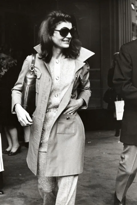 Jackie Kennedy Onassis When Jackie O became the First Lady of Fashion in the '60s, she influenced millions of women with her style. The simple shifts, pillbox hats, elegant scarves worn over her hair, oversized sunglasses, and peacoats inspired all generations of women to take note. Women everywhere still sport the "Jackie O" look today.
