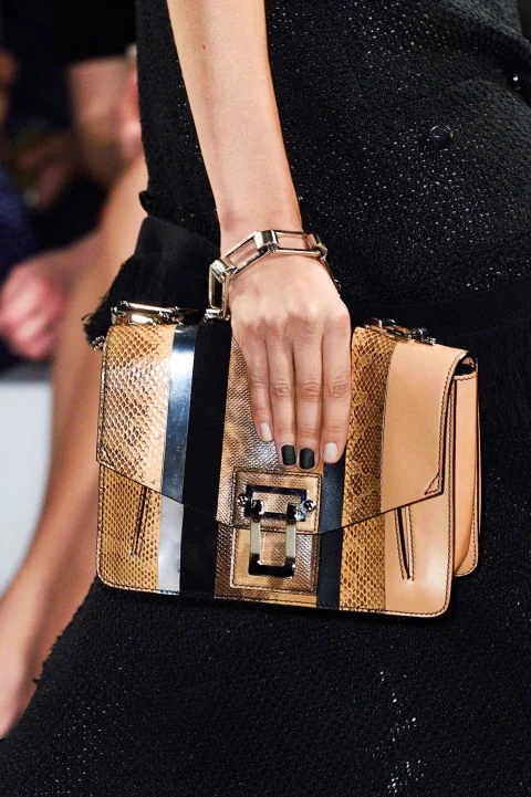 Spring's statement nail look couldn't be easier to re-create: Paint only two nails with a simple matte black. At Proenza Schouler, it was Essie Nail Color in Licorice with Matte About You top coat ($8.50 each). Apply a sheer light neutral on the rest for an allover polished effect, and for extra credit grab a graphic clutch. Proenza Schouler clutch, proenzaschouler.com .