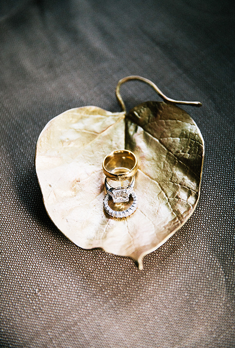Wedding rings sitting in a gilded jewelry dish. Photo: Lauria & Gennia of Docuvitae