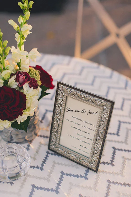  Photo: Mike Olbinski Photography The couple wanted to include pops of Art Deco style throughout their reception, so glam details were first introduced through their escort card display. Guests found their tables on white cards that were arranged on a mirrored table. On nearby cocktail tables, guests found silver-and-crystal frames that held quotes from Jay Gatsby's creator himself, F. Scott Fitzgerald.