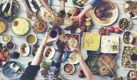 friends-sitting-around-table-in-restaurant-and-toasting-food-drink-dining_large.jpg
