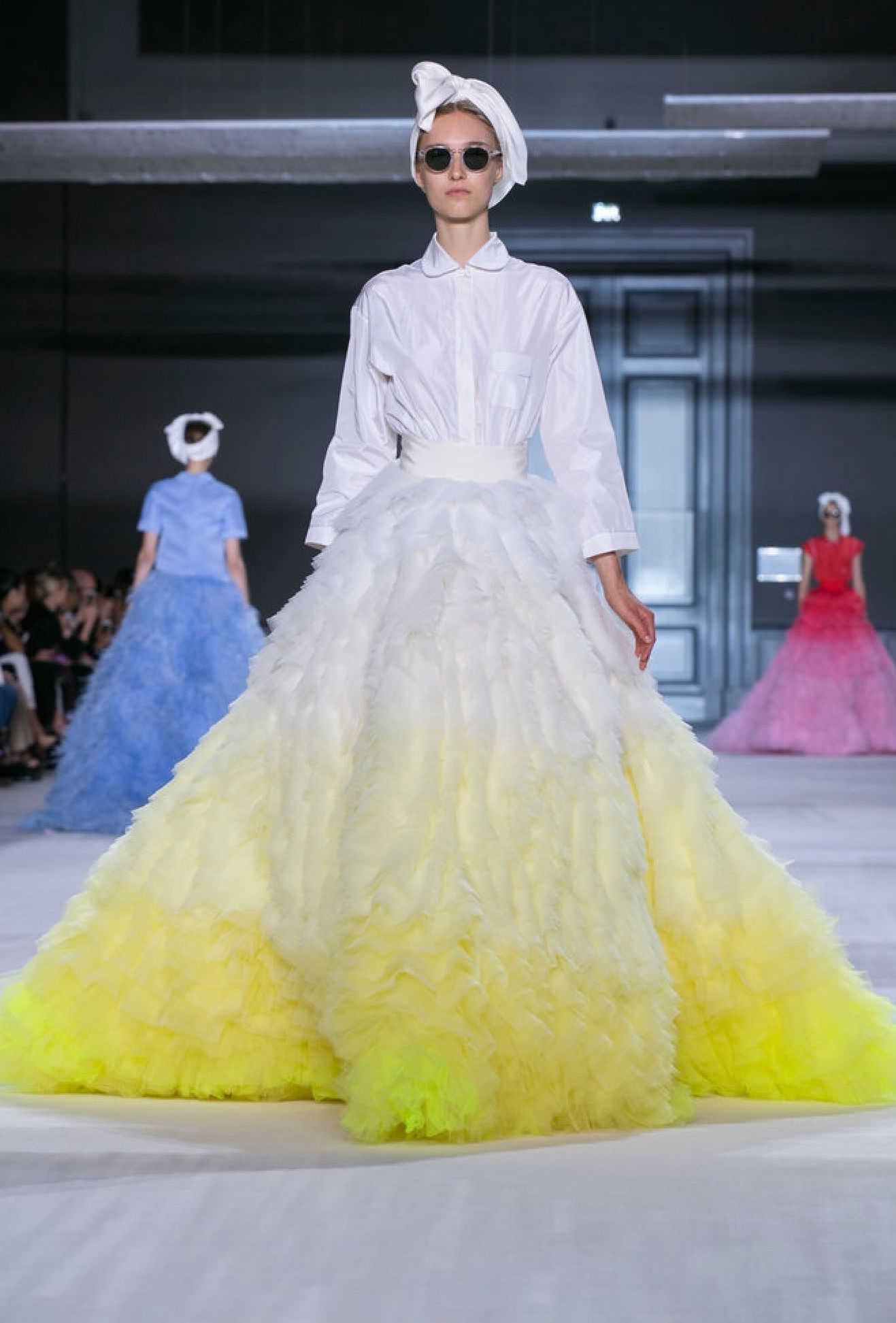The riotous colors of Giambattista Valli's ruffled feather skirt paired with an everyday shirt is just genius! The large framed glasses evoke the same period.