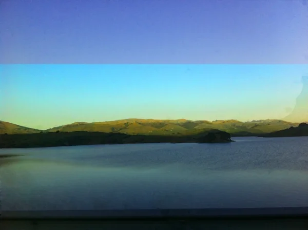 IMG_5197.Low hills above water with gold reflective glow 2.jpg