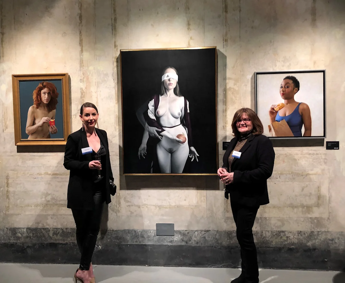 Megan Read and Nadine Robbins with their paintings - left Robbin’s Mrs. McDonald , middle Read’s Becoming , right Robbin’s Runin on Dunkin