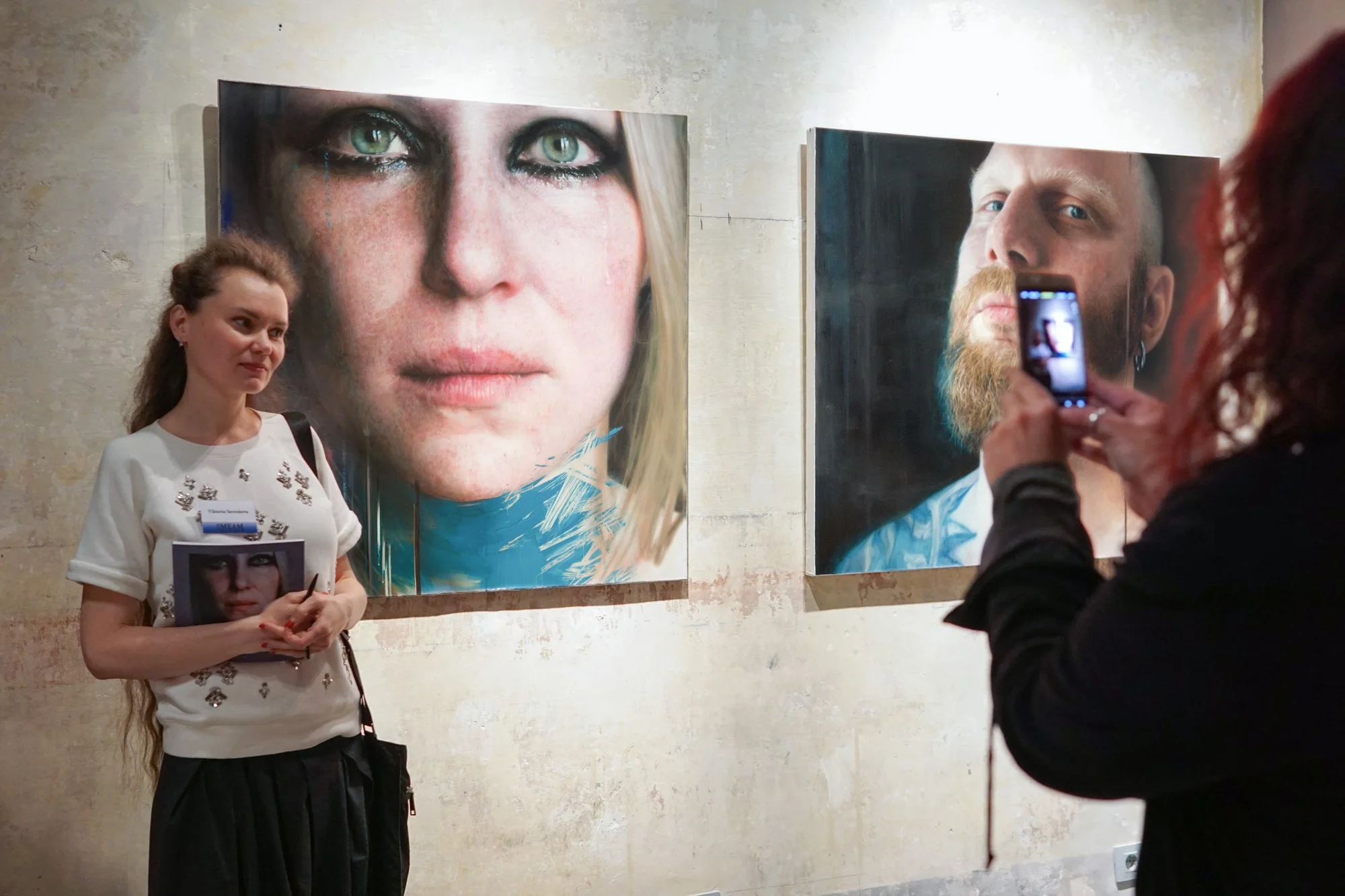 Viktoria Savenkova next to her paintings Blue 1 (left) and Ales (right)