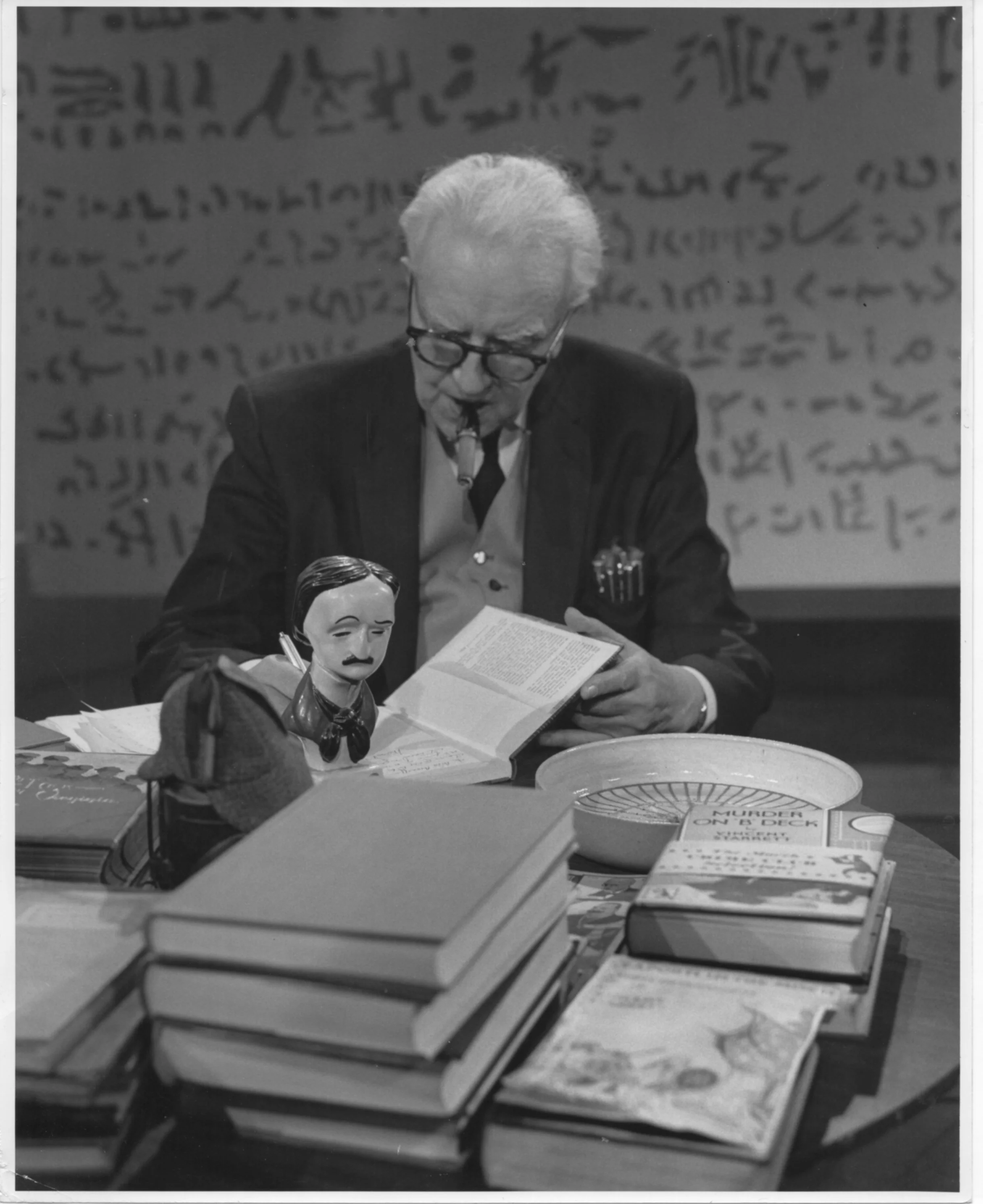 Vincent Starrett autographs some of his books. The major mysteries surrounding this photograph have been solved!