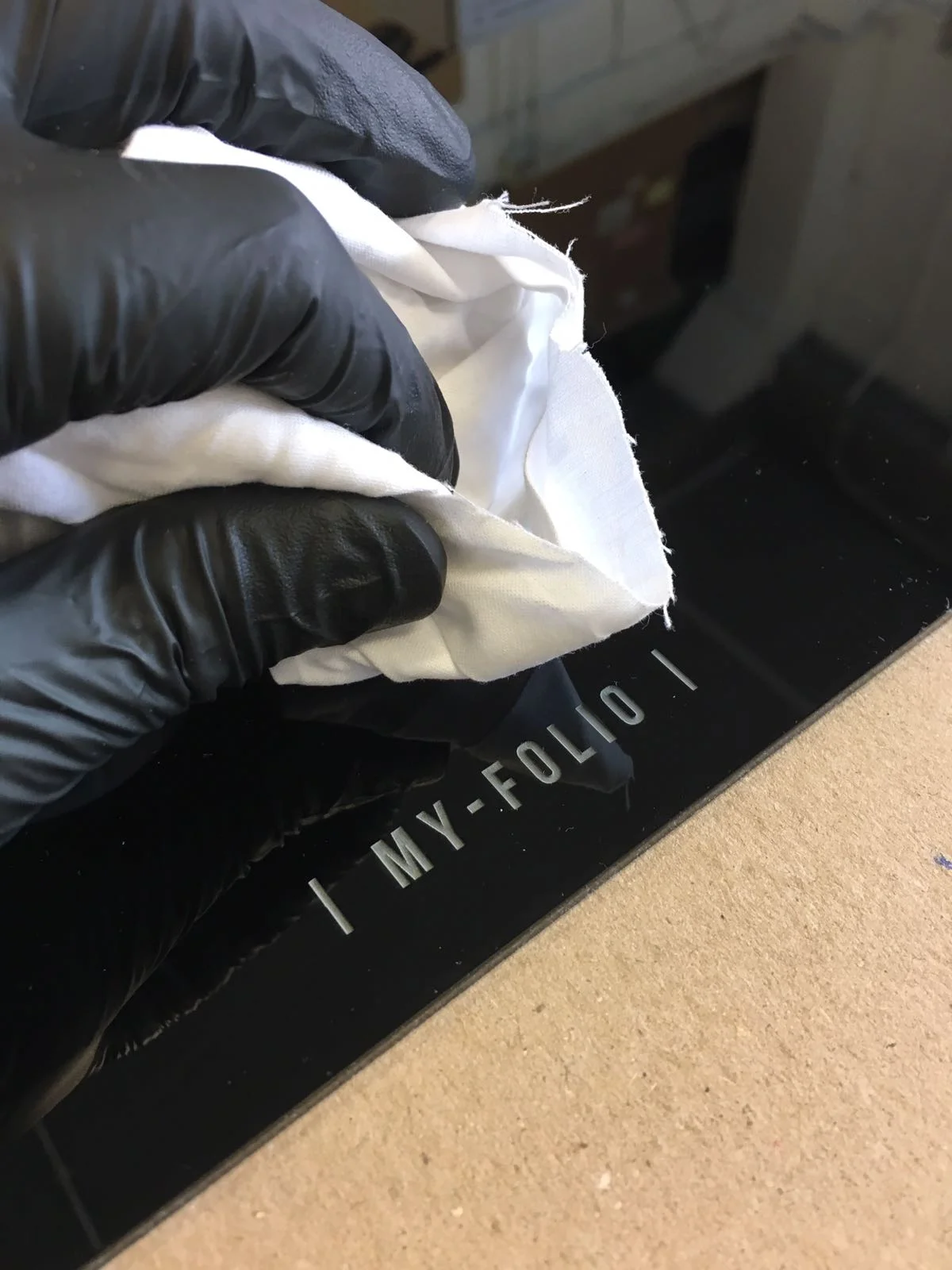 hand cleaning a black acrylic perspex display album